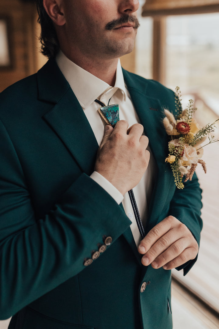 Photo of a Groom adjusting a Chrysocolla Bolo Tie