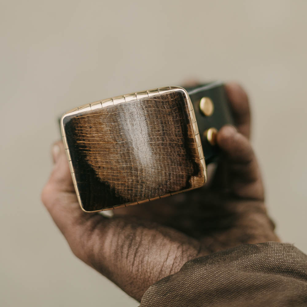 High Planes Driftwood Belt Buckle on Belt in Hand