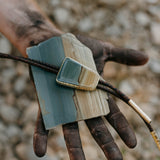 Discover the epitome of Western modern style with our handmade Succor Creek Picture Jasper bolo tie. Crafted with meticulous attention to detail, this unique accessory boasts captivating blue tones reminiscent of the serene Western skies. Elevate your look with a touch of rustic elegance that's entirely handmade, perfect for adding a bold statement to any ensemble.