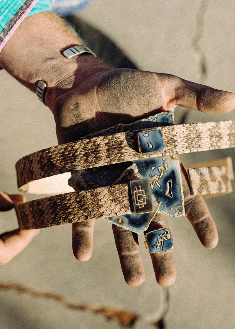 Custom rattlesnake skin hatbands, one with a tube agate gem stud and one with the HCBC brass hallmark, and a matching tube agate ring held with the raw slab